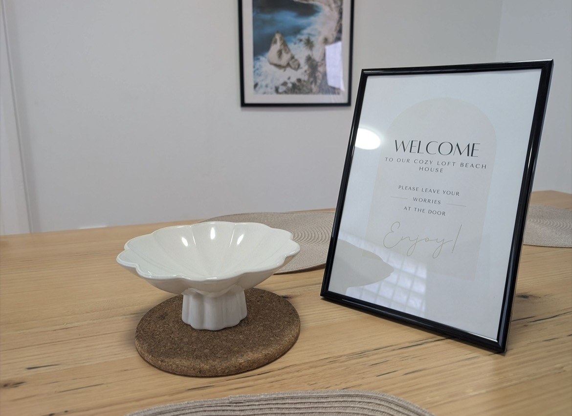 Framed welcome sign on the timber dining table