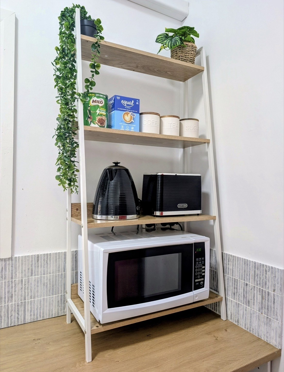 Kitchen shelves with kettle, toaster, microwave and tea and coffee canisters